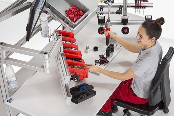 Asiento ergonómico en mesas de trabajo industriales